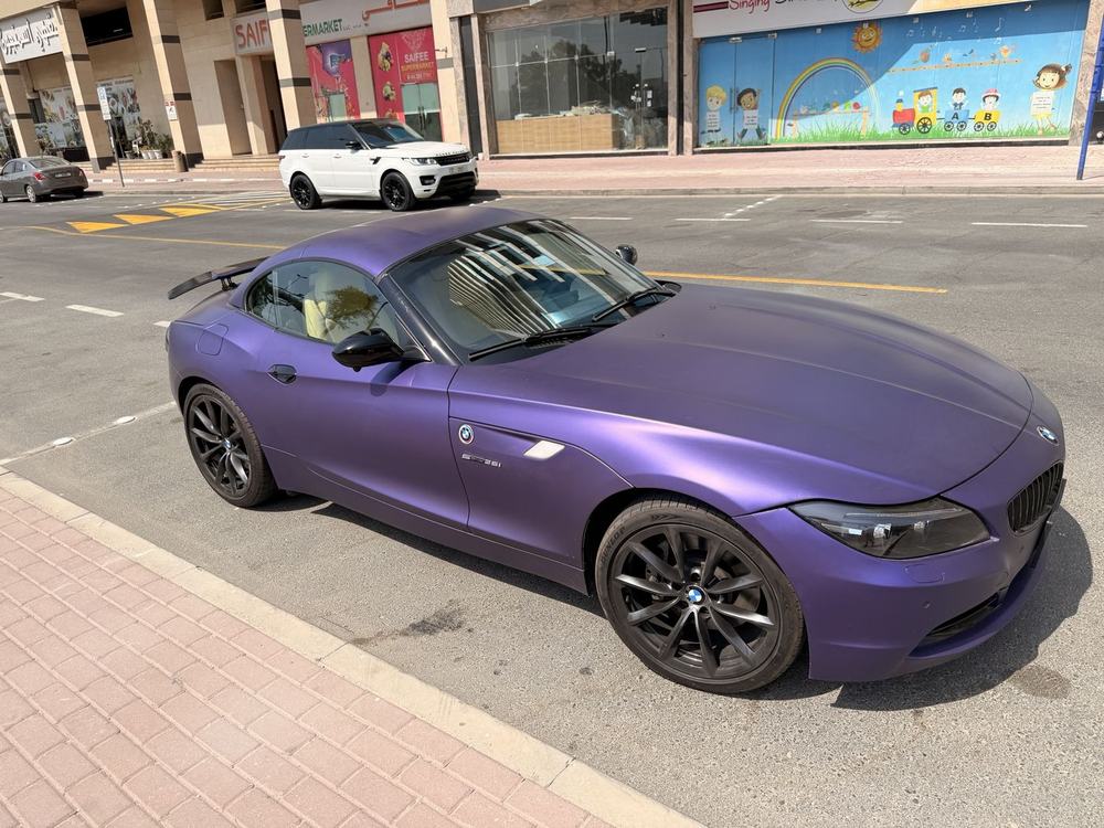 Owner's phone photo of a purple-wrapped BMW Z4 parked on a Dubai street
